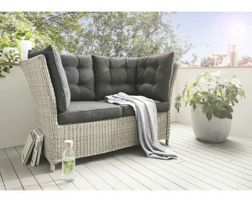 Ensemble de salon de jardin en rotin avec coussins gris sur une terrasse.
