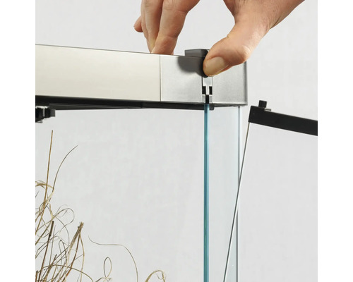 Detailansicht eines Aquariums mit Hand, die eine Abdeckung anbringt