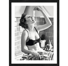 Schwarzweiß-Fotografie einer Frau, die in der Küche Spaghetti isst, gerahmt