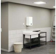 Lavabo avec meuble bas, chauffe-eau et échelle dans une pièce lumineuse