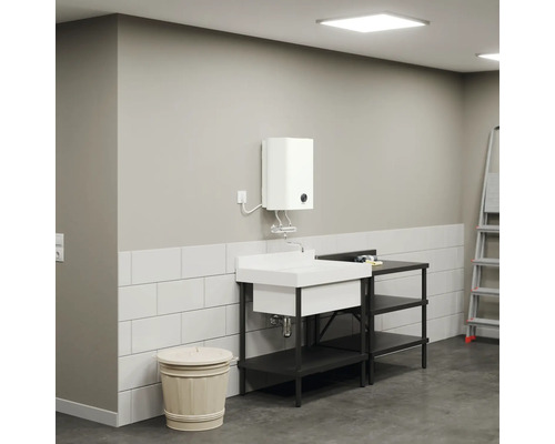 Lavabo avec meuble bas, chauffe-eau et échelle dans une pièce lumineuse