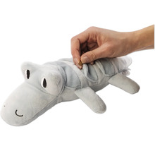 Graues Krokodil Plüschtier wird mit einem Leckerli gefüllt