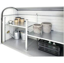 Innenansicht eines Gerätehauses mit Regalen und Gartenzubehör wie Giesskannen und Pflanzgefässen.