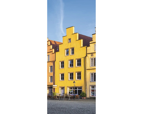 Gelbe Gebäude mit Fenstern und Tischen auf einem Platz