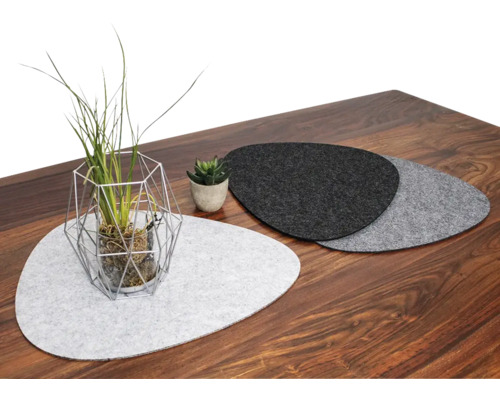 Dekoratives Arrangement mit Filzplatzsets, Topfpflanze und geometrischem Drahtgestell auf Holztisch