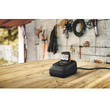 Chargeur de batterie avec batterie sur une table en bois