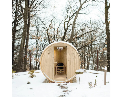 Sauna en forme de tonneau dans un jardin d'hiver avec de la neige