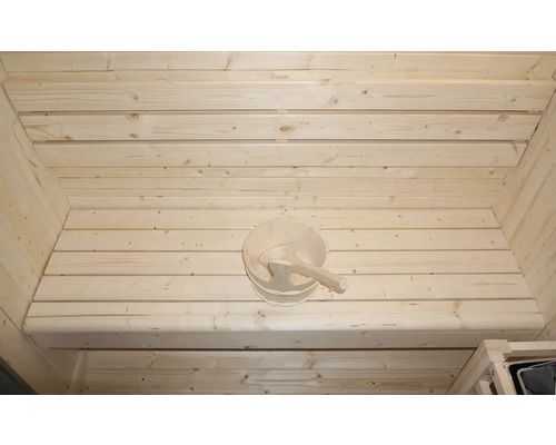 Intérieur d'un sauna avec mur en bois et seau en bois
