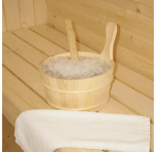 Seau en bois avec de la glace et une louche dans un sauna, à côté d'une serviette.