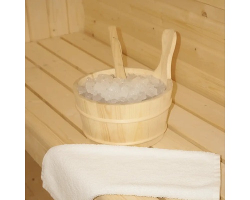 Seau en bois avec de la glace et une louche dans un sauna, à côté d'une serviette.