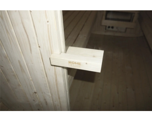 Intérieur d'un sauna avec le logo Home Deluxe sur un support en bois