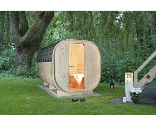 Sauna tonneau en bois dans le jardin avec éclairage