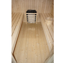 Aménagement intérieur d'un sauna avec bancs, poêle de sauna avec pierres et seau en bois
