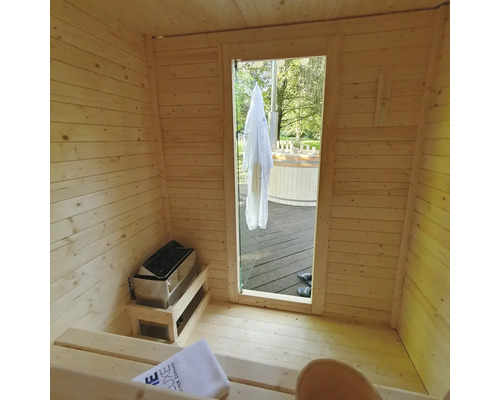 Vue intérieure d'un sauna en bois avec poêle de sauna et vue sur l'extérieur