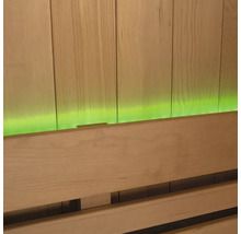 Gros plan d'un banc de sauna devant un lambris en bois avec éclairage vert