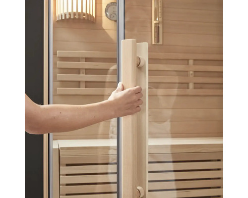 Main ouvrant la porte du sauna avec façade en verre et cadre en bois