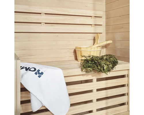 Sauna avec mur en bois, seau en bois, louche, branche de bouleau et serviette