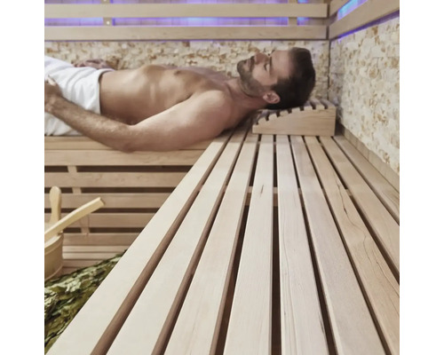 Mann entspannt in einer Sauna mit Holzbänken und Zubehör.