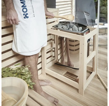 Sauna-Szene mit Person, Handtuch, Holzkelle, Steinen und Saunaofen