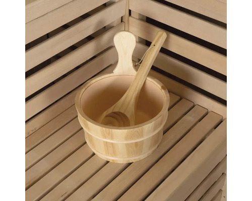 Seau de sauna en bois avec louche sur un banc en bois