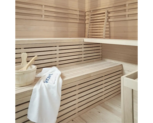 Sauna claire avec bancs en bois, seau en bois, louche et serviette
