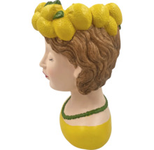 Pot de fleurs en forme de tête de femme avec une couronne de citrons