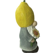 Gartenzwerg mit Zitrone als Kopf und Sonnenblume in der Hand