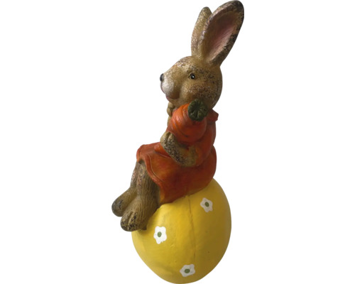 Osterhase auf einem gelben Ei als Gartendekoration