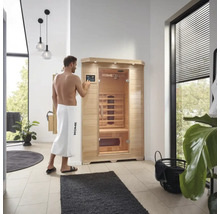Un homme utilise un sauna infrarouge Home Deluxe dans une salle de bain