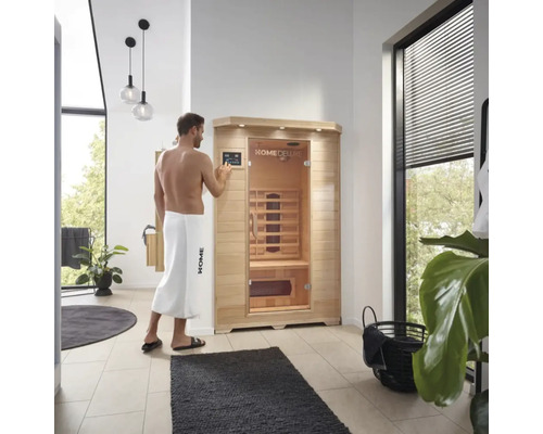 Un homme utilise un sauna infrarouge Home Deluxe dans une salle de bain