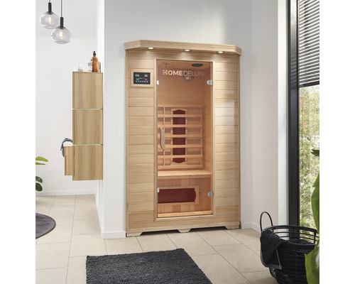 Sauna en bois avec porte en verre et éléments de commande dans la salle de bain