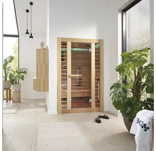 Pièce lumineuse avec sauna Home Deluxe, plantes et meubles de salle de bains.