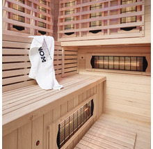 Intérieur d'un sauna infrarouge avec panneaux de bois, banc et serviette