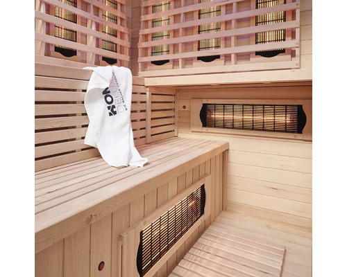 Intérieur d'un sauna infrarouge avec panneaux de bois, banc et serviette