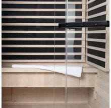 Vue intérieure d'un sauna avec lambris en bois, façade en verre et banc avec serviette