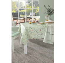 Gedeckter Tisch mit floraler Tischdecke in einem hellen Raum