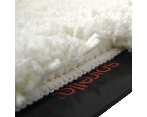 Vue détaillée d'un tapis de bain blanc à poils longs avec le logo Spirella.