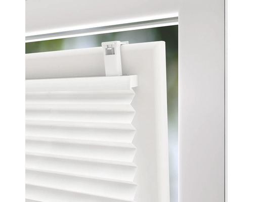 Vue détaillée d'un store plissé blanc sur une fenêtre