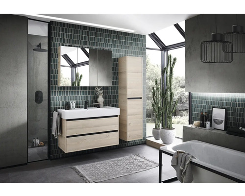 Salle de bains moderne avec lavabo, armoire de toilette, armoire haute et baignoire.