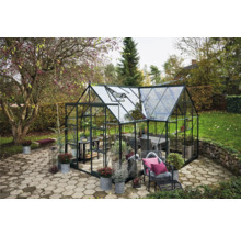 Serre avec plantes et meubles dans le jardin.