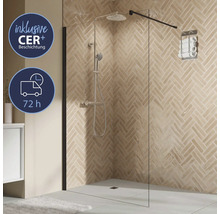 Paroi de douche en verre avec porte-serviettes et robinetterie de douche devant un mur carrelé