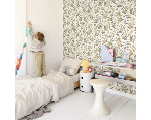 Chambre d'enfant lumineuse avec lit, table de chevet, étagère, tabouret et un mur avec du papier peint à motifs d'animaux.