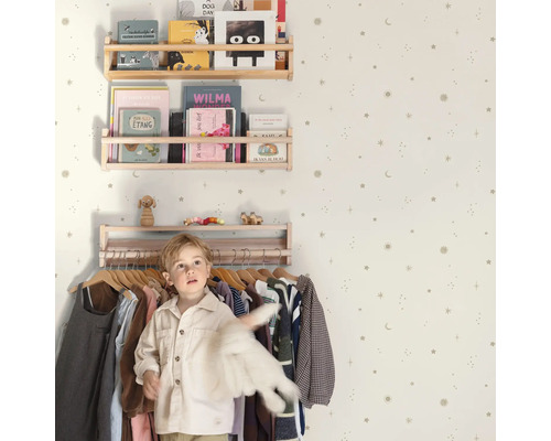 Chambre d'enfant avec étagères à livres, portant à vêtements et papier peint à étoiles