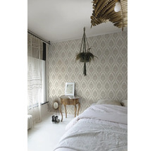 Chambre avec papier peint à motifs, lit, table de chevet et plante d'intérieur