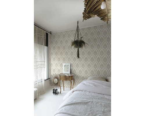 Chambre avec papier peint à motifs, lit, table de chevet et plante d'intérieur