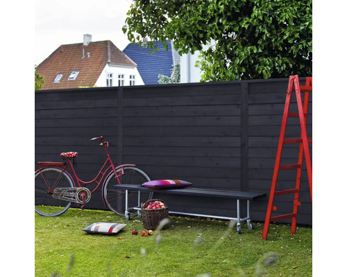 Scène avec clôture en bois, banc, vélo et échelle dans le jardin