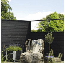 Dekorative Gartenszene mit Holzzaun, Pflanzkübel, Rattansessel und Pflanzen