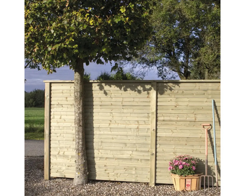 Clôture en bois avec arbre, panier de fleurs et outils de jardin à l'extérieur