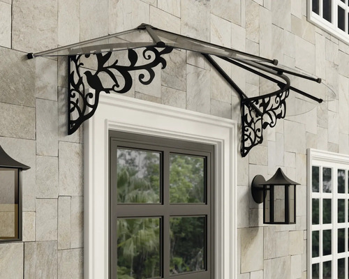 Marquise de porte avec toit transparent et supports noirs ornementés au-dessus d'une porte sur une façade en pierre.