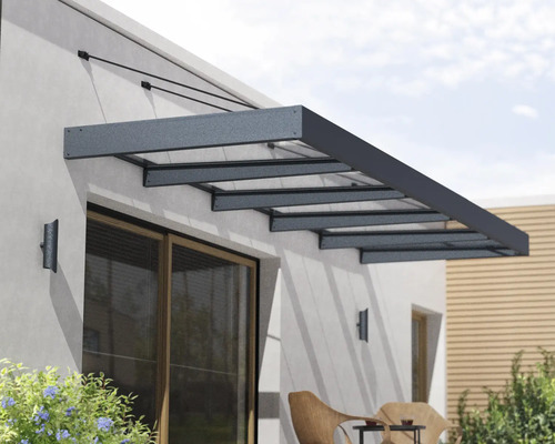 Marquise moderne en aluminium et verre au-dessus d une porte de terrasse sur un mur extérieur.